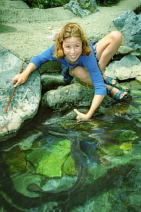 f211610: girl lifts eel triumphantly